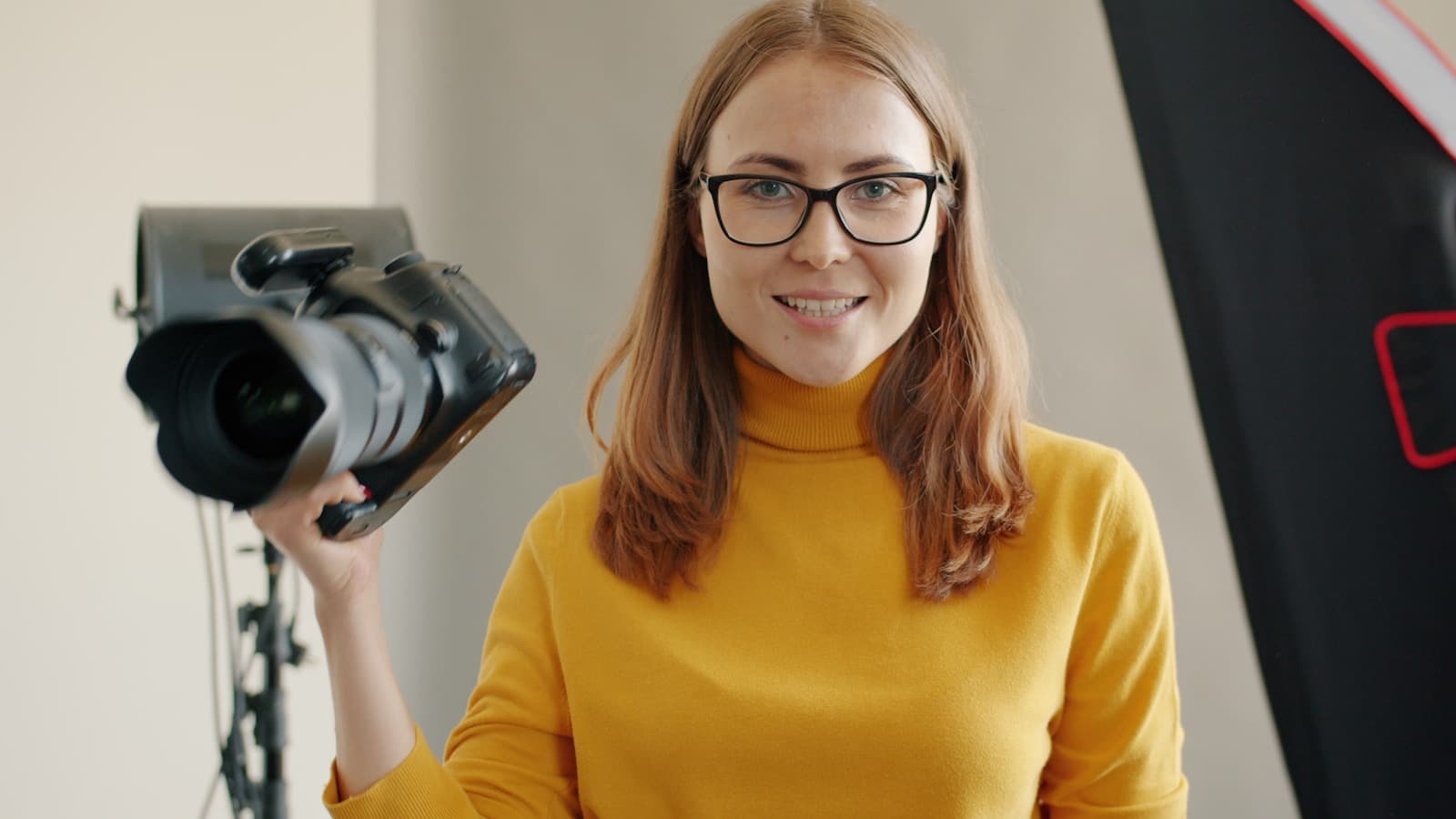 Photographer Nia Brooks represented by a woman holding a camera in a studio
